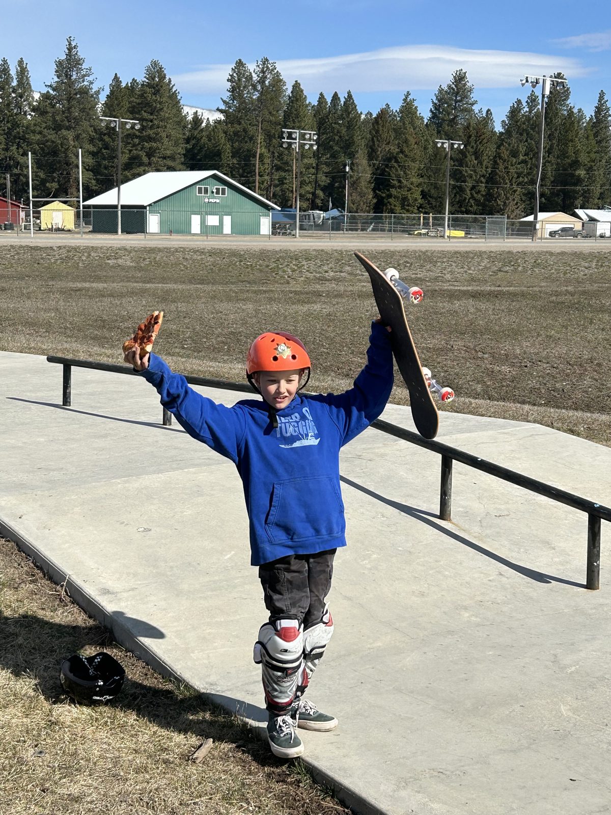 Young rider celebrating with pizza and skateboard